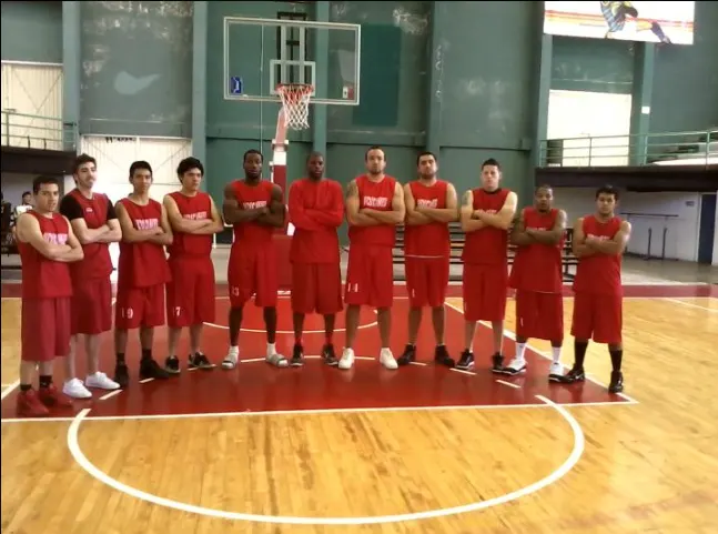 Equipo Volcanes de Toluca formado en el medio de la cancha, con uniforme rojo.