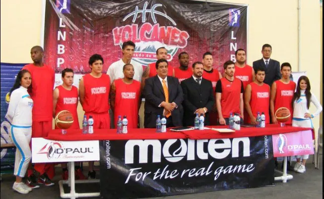 Plantilla de Volcanes de Toluca en una presentación de la LNBP, con la lona del equipo detrás de la banca.